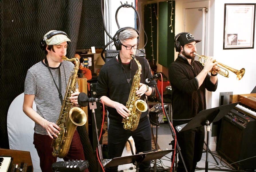 A horn section playing in the studio